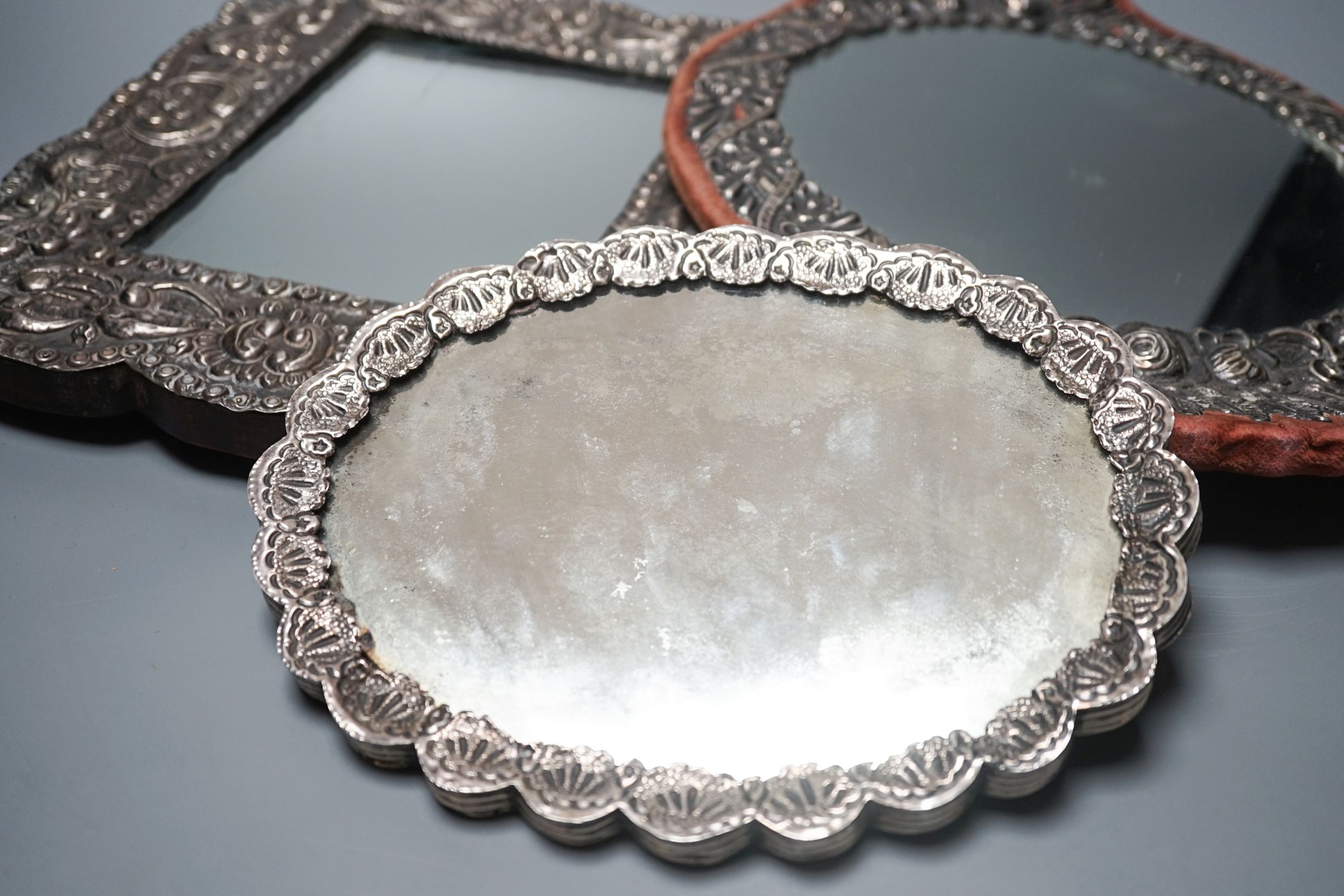 Three assorted Turkish white metal mounted mirrors, largest, 32.2cm.